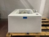 a white bath tub sitting on a pallet in a room