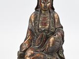 an image of a statue of a woman sitting on a rock