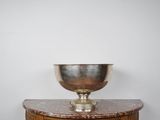 un bol en argent posé sur une table en bois
