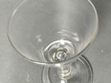 a wine glass sitting on a table next to a bottle