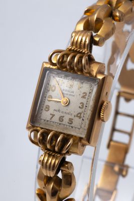 l'image d'une montre-bracelet en or entourée d'une chaîne