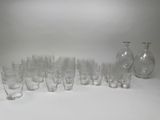 des bouteilles et des verres sont alignés en rang sur une surface blanche