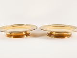 a pair of gold plated candlesticks on a white background