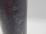 a close up of a black vase on a white table