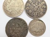 four different types of coins are shown on a white surface