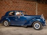 a blue car that is parked in front of a brick wall