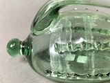 a green glass bottle with a ship inside of it