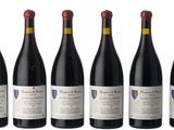 six bottles of red wine are lined up in a row