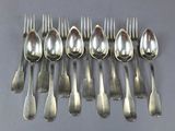 six spoons and a fork are arranged in a row on a table