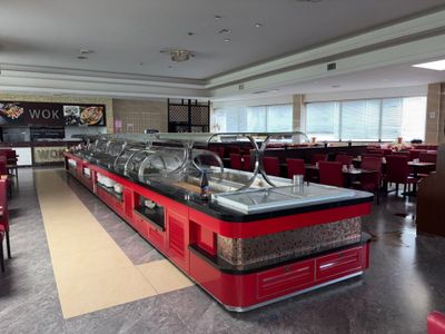 des tables et des chaises dans un restaurant, avec un buffet en arrière-plan