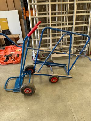 un diable bleu avec une poignée rouge dans un garage