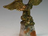 une image représentant une statue d'oiseau ailé posée sur un socle en marbre