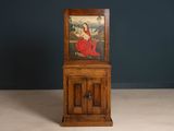 an old wooden cabinet with a painting of a woman on it
