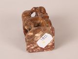 figurine of a dog on a rock with a tag in its mouth