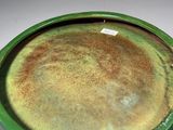a green vase sitting on a table with a tag on it