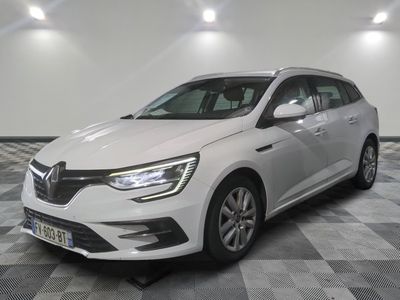 une voiture blanche est garée dans une pièce au sol en damier