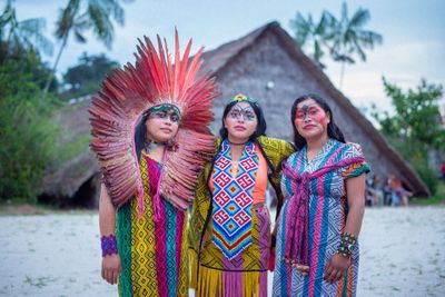 trois femmes vêtues de vêtements colorés, debout les unes à côté des autres