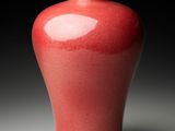 a red vase that is sitting on a table