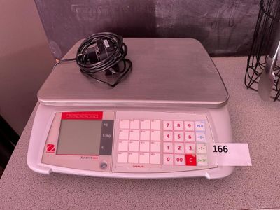 une balance électronique posée sur une table, reliée par un câble