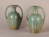 two green vases sitting next to each other on a table