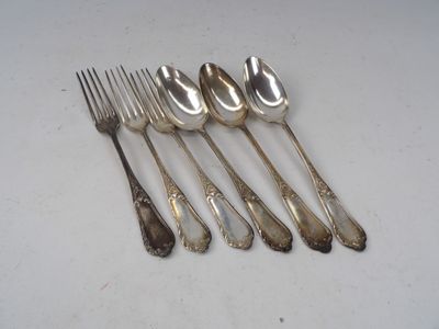six cuillères en argent et une fourchette sont alignées sur une table