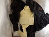 a pile of clothes and a jacket on a bed