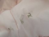 a close up of a pink blanket with green leaves on it