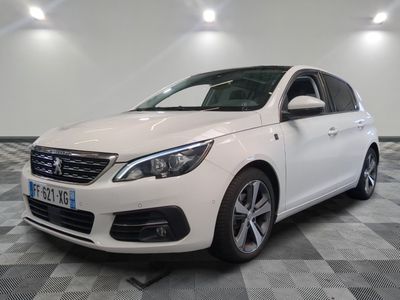la voiture blanche est garée sur un sol en damier dans le garage