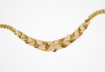 gros plan d'un collier en or sur fond blanc