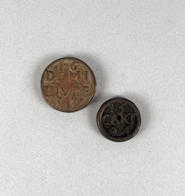 une vieille pièce et une petite pièce posées sur une surface blanche