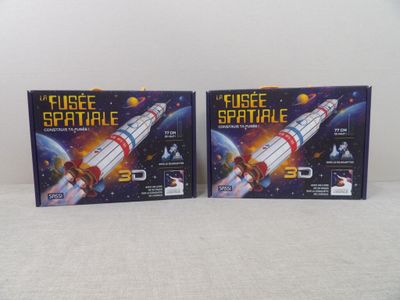 Deux boîtes de jouets spatiaux en plastique sont posées sur une table