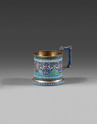 une tasse bleue et dorée avec une anse, posée sur une surface grise