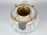 a clear glass vase with a gold rim on a white surface