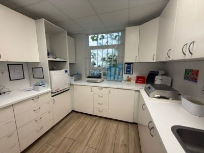 an image of a kitchen with white cabinets and wood flooring