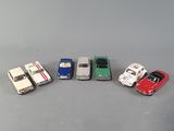 several toy cars are lined up in a row on a gray surface