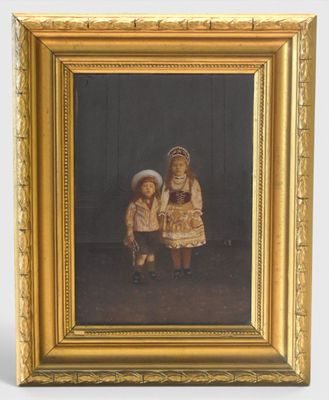 painting of two children in a gold frame with a black background