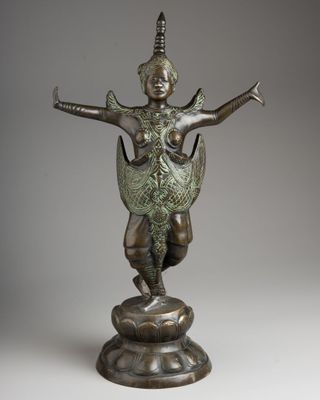 a bronze statue of a woman holding a bird on a pedestal