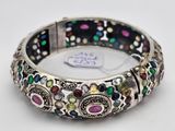 a close up of a bracelet with multi colored stones on it