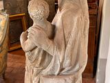 a statue of a woman holding a child in a room