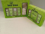 two boxes of tea tree products sitting on a white surface