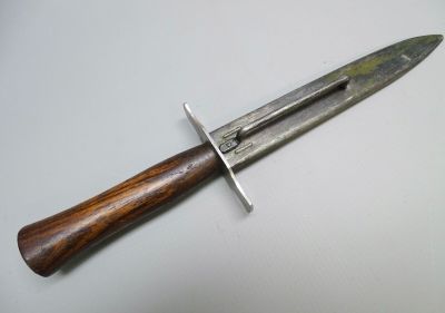 gros plan d'un couteau avec un manche en bois sur une surface blanche