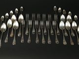beaucoup de cuillères et de fourchettes disposées ensemble sur une table