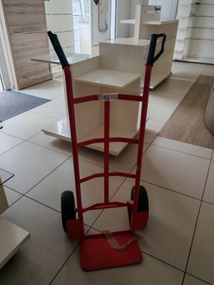 a red hand truck that is sitting in the middle of a room