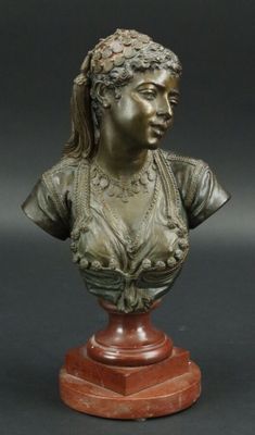 un petit buste en bronze représentant une femme, posé sur un socle en bois