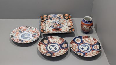 quatre assiettes et un vase posés sur une table