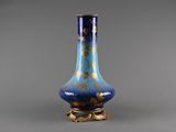 a blue and gold vase sitting on a table