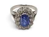 a close up of a blue sapphire and diamond ring on a white background
