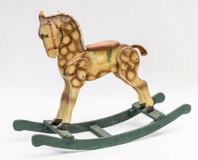 a small wooden rocking horse with a saddle on it ' s back