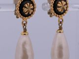 a pair of pearl and gold earrings with black and white pearls