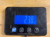 a digital clock on a wooden table with a cord